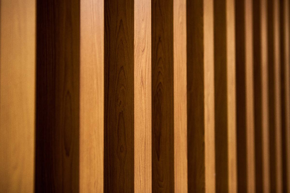Close view of walnut-tone fluted wall panels showing the ribbed profile