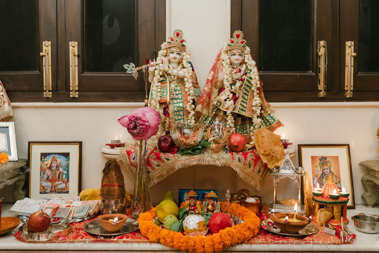 Home mandir with idols, flowers and diyas in a pooja room