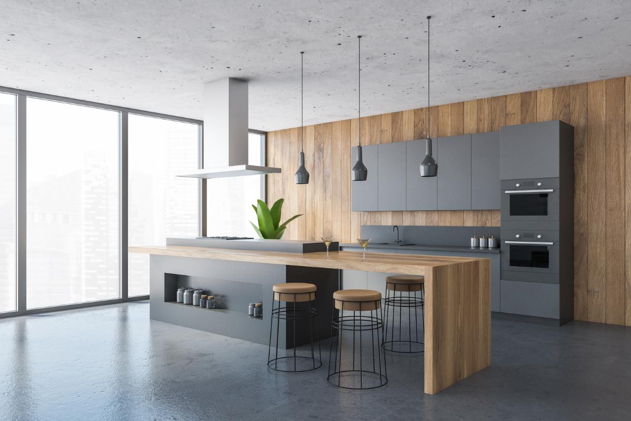 Open kitchen with a wood plank wall behind grey cabinets and an island with bar stools