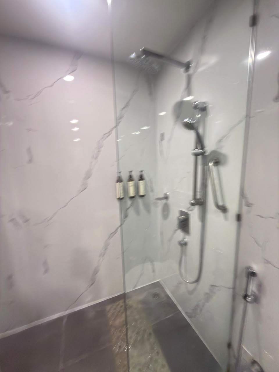 MAESTA UV marble sheets lining a hotel shower enclosure, a real Urbane Decor installation in Pune