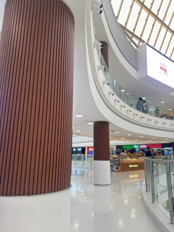 Fluted WPC column cladding under the skylight of a Mumbai mall atrium, a real Urbane Decor installation