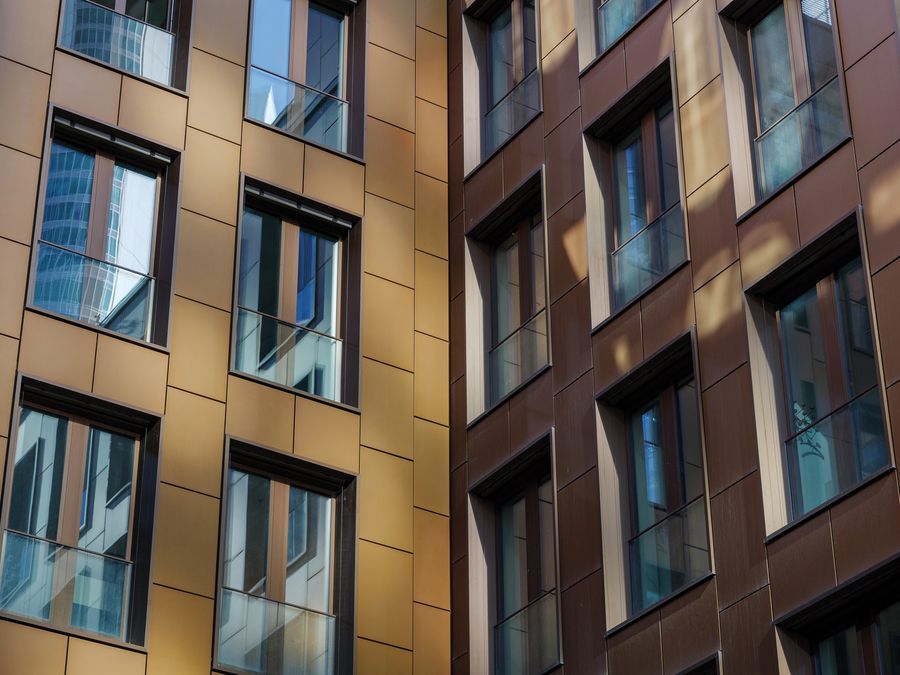Building facade clad in gold and bronze metal composite panels around windows